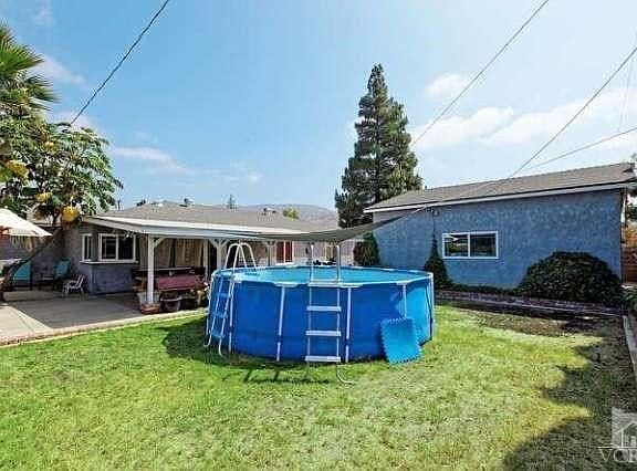 Backyard has grassy yard, patio w/solid overhang