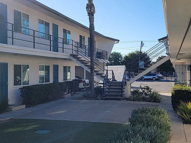 Front of courtyard area with stairs to upper apartments at Orlando Woods Apartments in El Cajon, California.