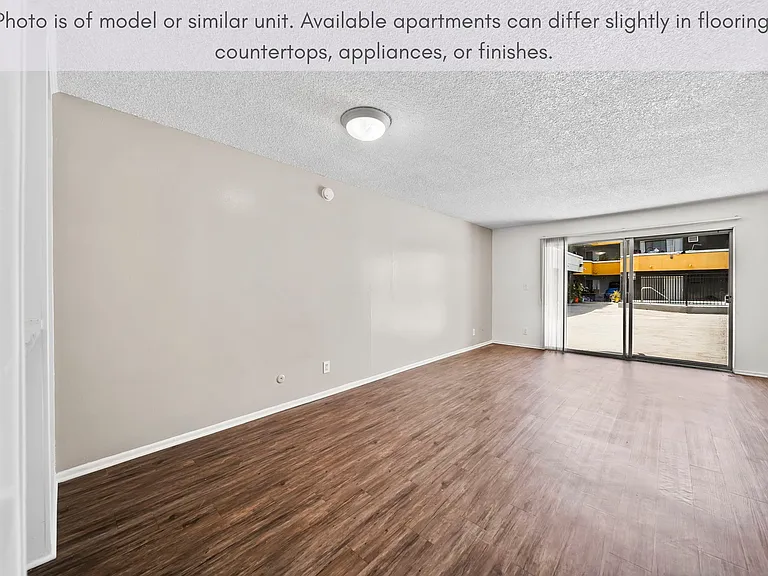 Spacious living area featuring updated flooring and sliding door access to the outdoor space.