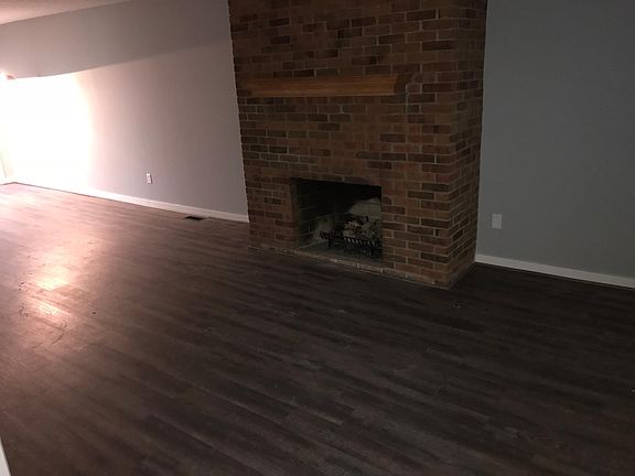 Gas log fireplace in living room with new floors