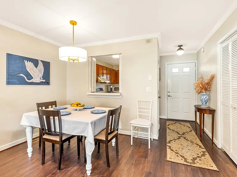 View of the dining area and front door/foyer and kitchen.
