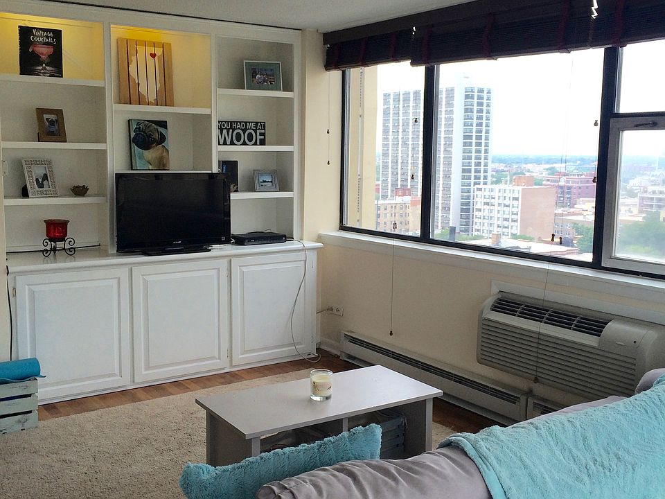 SPACIOUS LIVING ROOM WITH BUILT IN MEDIA CASE AND VIEWS OF T