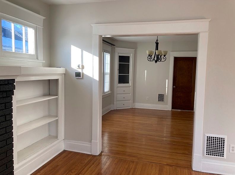 Living room archway into dining room, showing chandelier and built-ins.