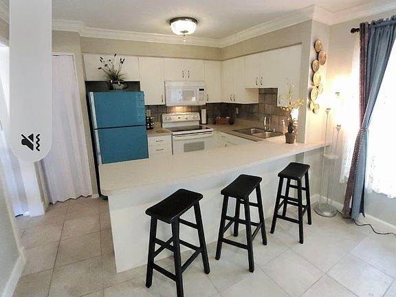 Fully Stocked Kitchen with Breakfast Bar, Microwave and Full Sized Refrigerator.