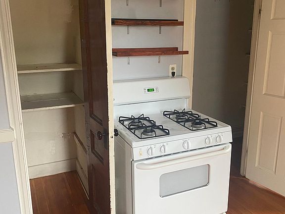opposite side of kitchen w stove and pantries