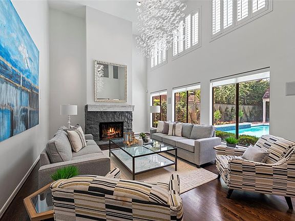 This living room is AMAZING! Soaring ceilings with dramatic chandelier and lots of windows overlooking the large pool!