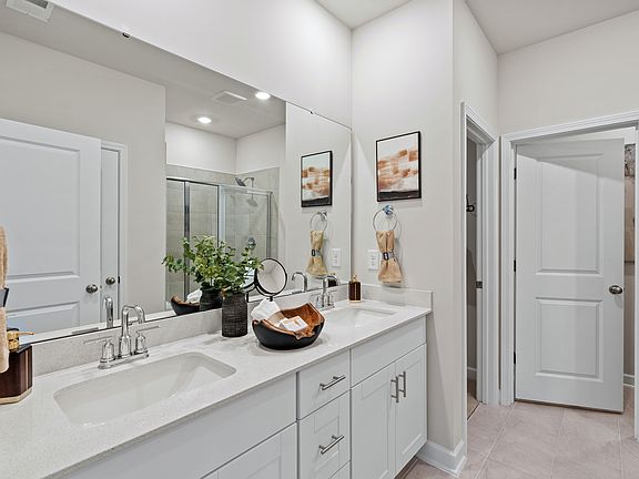 The primary bathroom boasts dual sinks, spacious shower and large walk-in closet.