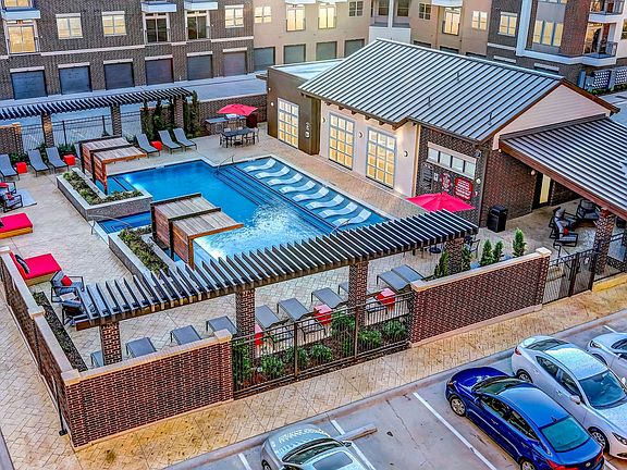 Courtyard pool with outdoor lounge seating and BBQ grills
