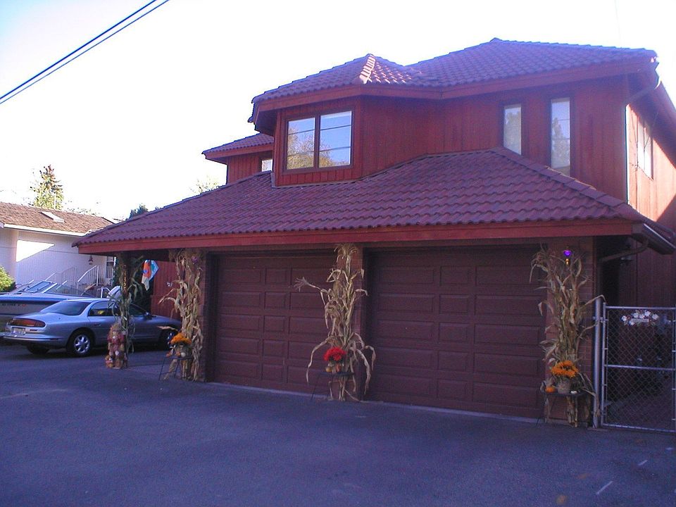 Red brick, tile roof, 4 car garage, one is tall enough for a RV.  2 bedrooms look out from here