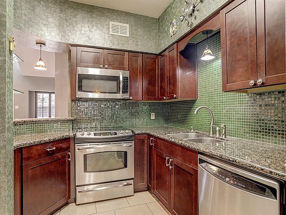 Remodeled kitchen with new cabinetry, granite counters, and SS appliances