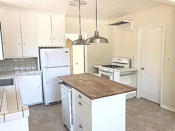 Gas range with built-in storage areas.