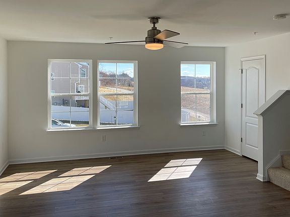 Living room with 3 large windows in a DRB Homes York II Garage home in the Homestead Acres community
