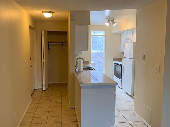 View of entry and kitchen from living area