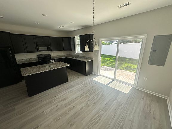 Kitchen, includes Fridge, Electric Oven, Microwave oven and Breakfast Island. Sliding door to patio.