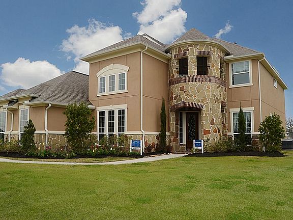 The stucco and stone exterior of this stately home is complimented by intersecting hip roof lines, d