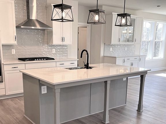 Island kitchen with white cabinets in a DRB Homes Colton II plan in the Barron Heights community.