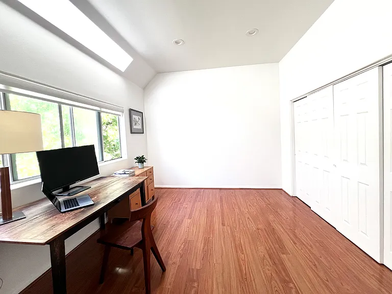 Functional second bedroom featuring custom built-in bookshelves and an integrated closet system.