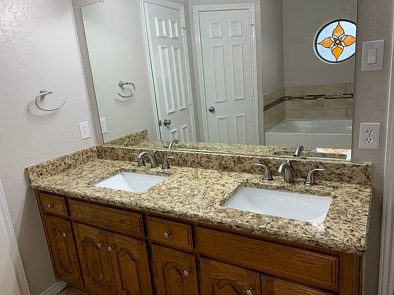 MBR Bathroom with updated, double sinks, and fixtures, two closets His/Her's, one on each side of the tub.