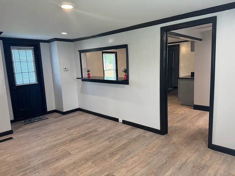 Full view of living room, serving hatch and entry way into the kitchen