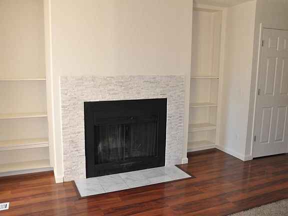 front room, natural wood fireplace and built-in shelves