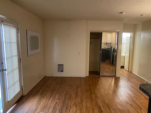 Vinyl wood plank floors, mirrored sliding closet doors, hallway to the bathroom