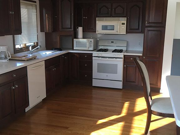 Kitchen with custom cabinets and white appliances. Built in 