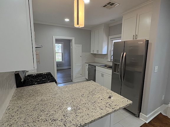 Kitchen with granite, peninsula, and new stainless steel appliances.