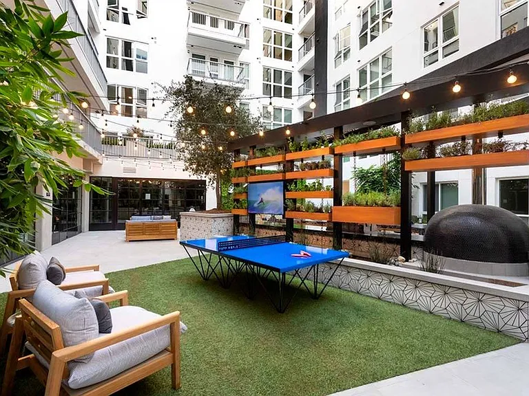 Outdoor games and lounge seating behind the outdoor kitchen in the courtyard at Modera San Diego