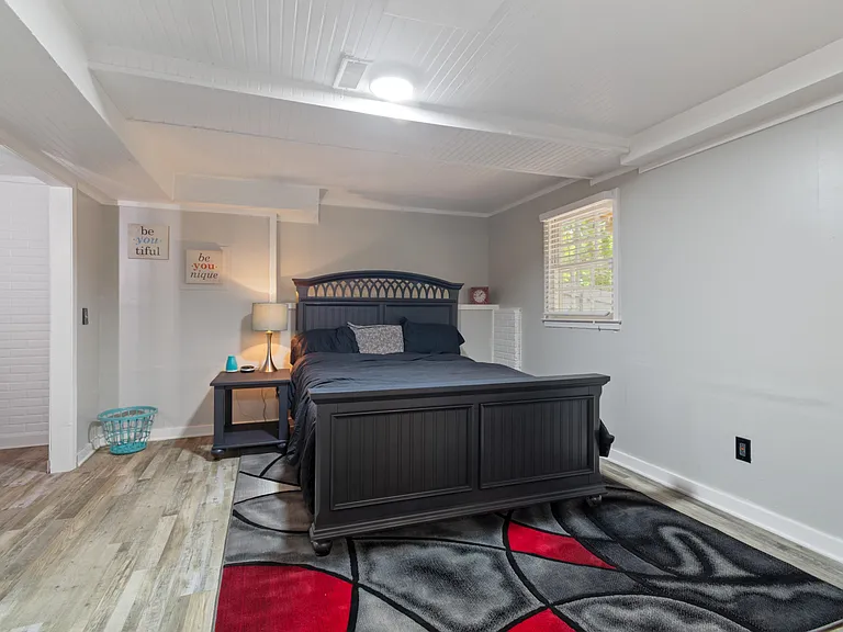 large primary suite bedroom with private on suite bathroom, larger walk in closet, small desk work station, queen bed, and on