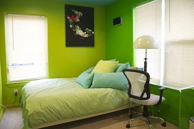 The green room boasts a full-sized bed, an acrylic desk and