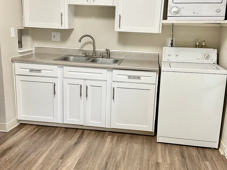 Streamline your lifestyle with this chic kitchenette and convenient laundry setup. Streamline your lifestyle with this chic kitchenette and convenient laundry setup.