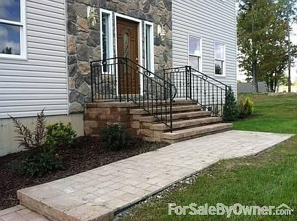 Close up of railing
						:
						solid iron railing with beautiful details and walkway with pavers