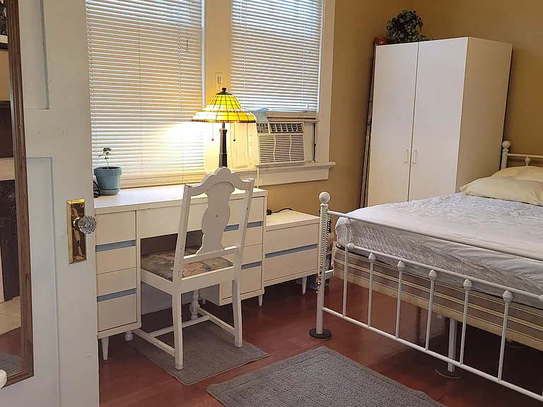 Full sized mirror on inside of closet door and the mirror of the dresser allow for unusually clear views of what a tenant is wearing! 60s bedroom set in white and touches of blue give a calming effect to the room along with the warm neutral paint colors a