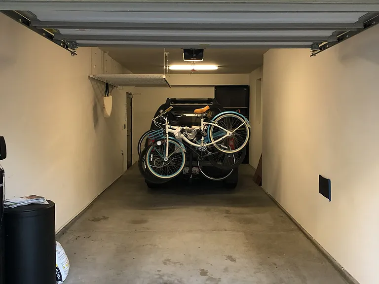 Tandem garage with overhead storage. Water softener. Nissan Pathfinder with bikes for scale purposes.