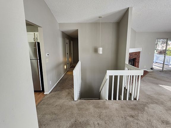 Open staircase leading to basement and hallway leading to upstairs bedrooms