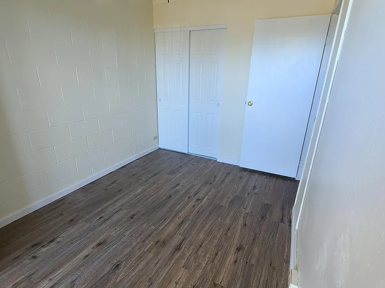 Bedroom 2 with sliding closet doors and opening to patio area.