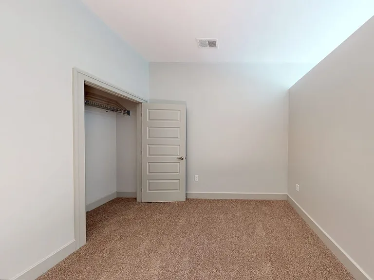 Spacious apartment bedroom with plush carpet flooring