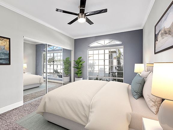 Carpeted bedroom featuring beautiful natural lighting and ceiling fan.