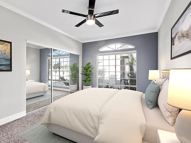 Carpeted bedroom featuring beautiful natural lighting and ceiling fan.