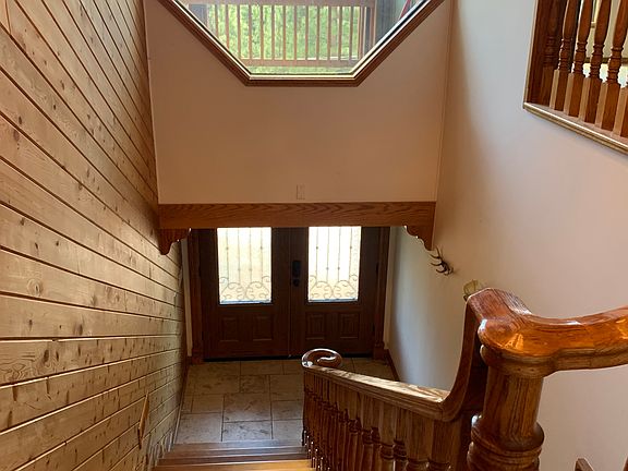 Stairs leading to the front door and above it is the view of the deck from the living room