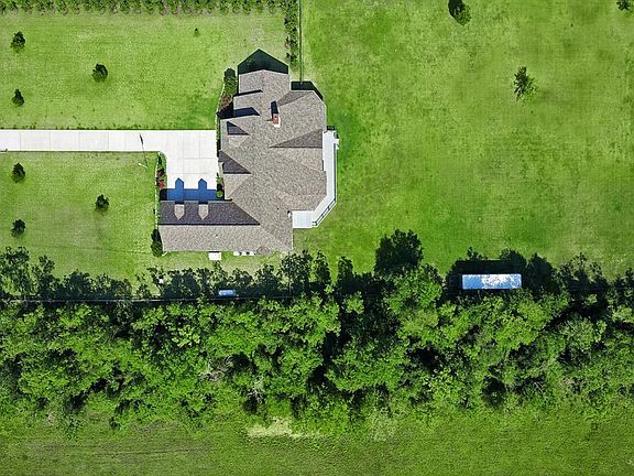 In this aeriel shot you can see all 3 acres. All 3 acres are fenced and there is a gate on each side separating the front from the back. The trees are included in the property and offer added privacy.