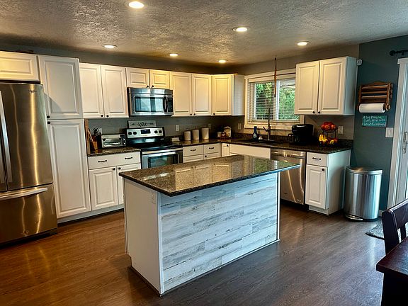 Kitchen with granite countertops and large island, access to backyard through sliding glass door.