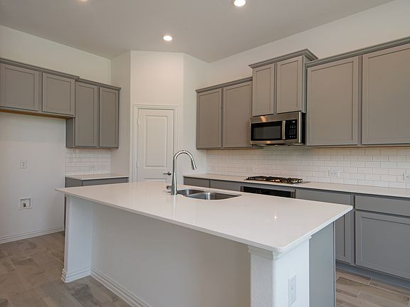 Modern kitchen featuring quartz countertops, ample cabinetry, and state-of-the-art appliance