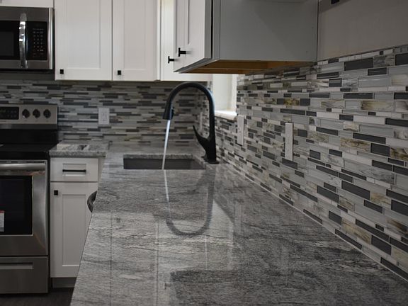 Fully updated Kitchen with island, granite countertops, New Cabinets and Backsplash. The home has New Stainless Steel Appliances and New Light Fixtures.