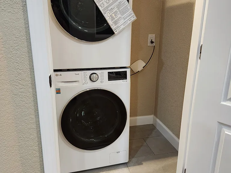 Laundry room w/ tile floor and storage.