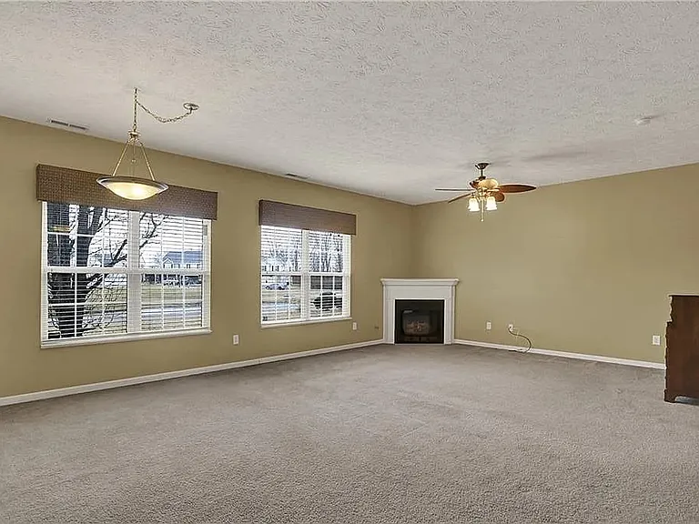 The living room carpet floor has been replaced to light grey hardwood.
