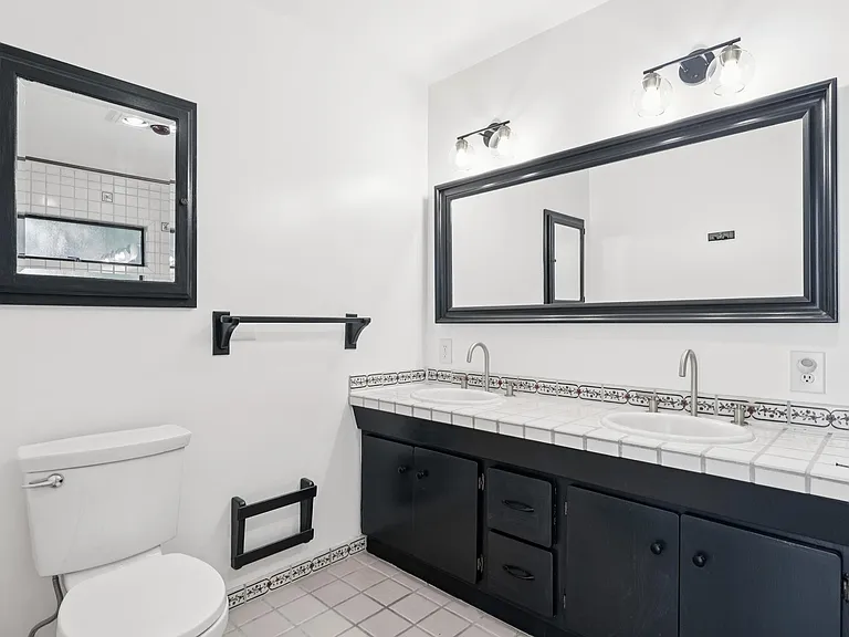 Primary bathroom with dual vanity, new light fixtures.