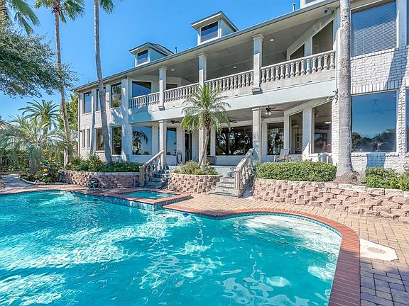 GRAND ENTERTAINING AREAS INCLUDING THE BALCONY, LARGE POOL WITH ROCK WATERFALL, EXPANSIVE VERANDA AND PAVERED PATIO.