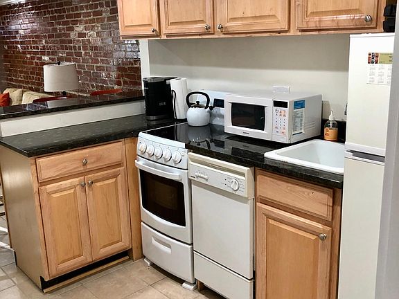 Fully equipped kitchen with new stove and small appliances.