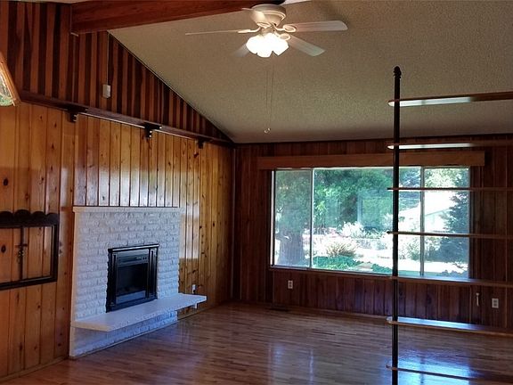 Stunning custom living room includes fireplace and ceiling fan.